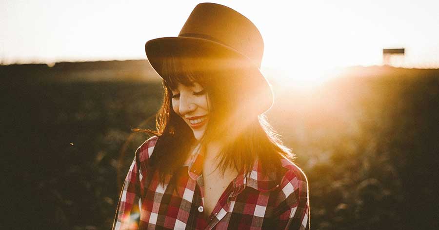 woman smiling with sunset in the background