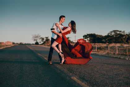 A photo of a couple in a dancing pose in the middle of a deserted street