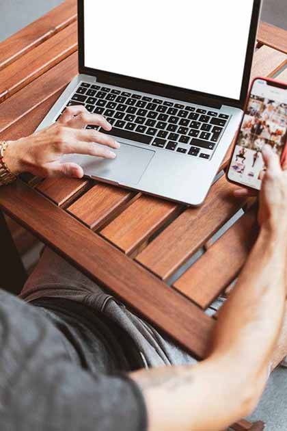 A photo of a man on his laptop and phone